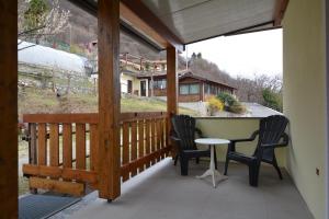 a porch with two chairs and a table on it at Agriturismo Runchee in Vercana