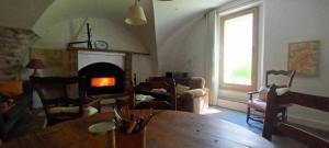 a living room with a table and a fireplace at Maison Authentique en Ubaye in Jausiers