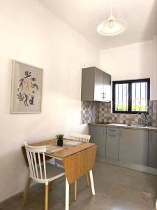 a kitchen with a wooden table and chairs in a room at Tony's Garden House in Lefkimmi