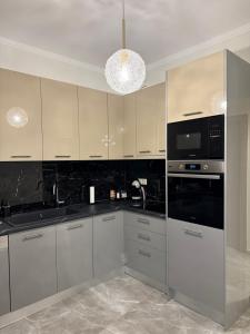 a kitchen with white cabinets and black counter tops at Hotspot Acharnes in Acharnes