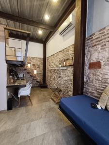 Zimmer mit blauem Bett und Ziegelwand in der Unterkunft Hermoso apartamento con patio privado in Cartagena de Indias
