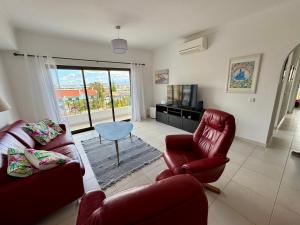 un salon avec deux chaises et une table et une télévision dans l'établissement Apartment Lindamar, à Lagos