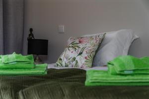 a bed with green towels on it with a pillow at Vivenda da Bela Vista in Ponta Delgada +37 photos