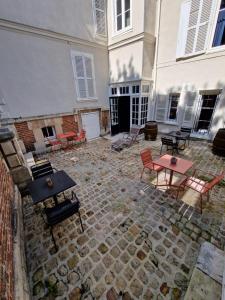 a courtyard with tables and chairs and a building at Le Clos Guivet in Troyes