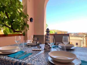a table with plates and wine glasses on it at Modern Seaview Townhouse - Workcation friendly in Orosei