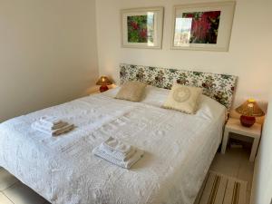 une chambre avec un lit blanc avec des serviettes dessus dans l'établissement Apartment Lindamar, à Lagos 39 autres photos