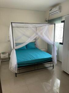 a bed with a canopy in a room at Soleil ak Jàmm in Mbour