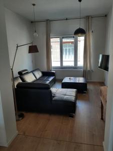 a living room with a black couch and a table at APP Amsterdamstr glv in Ostend