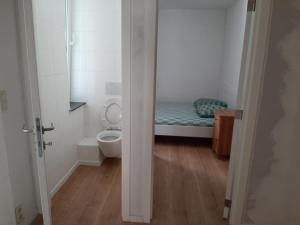 a bathroom with a toilet and a bed in a room at APP Amsterdamstr glv in Ostend