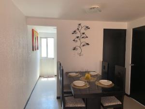 a dining room with a black table and chairs at Cuarto amueblado para dama in La Cañada