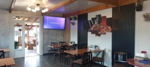 a restaurant with tables and chairs and a tv on the wall at La Maria in Şuncuiuş