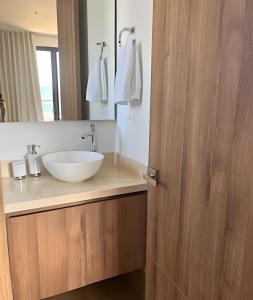 a bathroom with a white sink and a mirror at Brand New Apt Pool & City Views in Cartagena de Indias