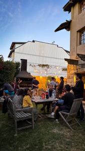 a group of people sitting around a table in the grass at Periko´s Youth Hostel in San Carlos de Bariloche