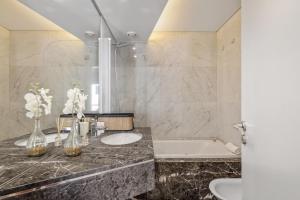 ein Badezimmer mit zwei Waschbecken und einer Badewanne in der Unterkunft Forum Ocean View 5C by Homie in Ilhéu do Gorgulho + 16 Fotos