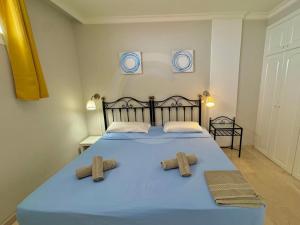 Un dormitorio con una cama azul con dos toallas encima. en Mogán harbor apartment, en Puerto de Mogán