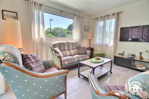 a living room with chairs and a couch and a tv at Le goeland in Auray