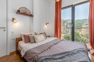 Un dormitorio con una cama con una ventana grande. en The Royal Summer & Spa, en Bečići 126 fotos más