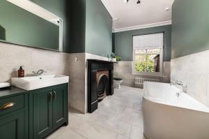 a bathroom with a tub and a sink and a fireplace at Riversdale House Bed & Breakfast in Llangollen +46 photos