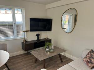 ベルファストにあるFisherwick House Apartmentsのテーブルと鏡のあるリビングルーム +22枚の写真