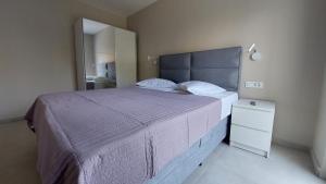a bedroom with a large bed with a purple bedspread at Apartman Katarina in Brodarica