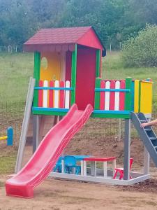 a playground with a slide and a house at Lacurile IRION in Hoghilag
