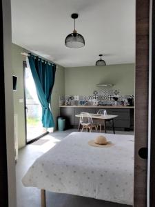 a living room with a table and a kitchen at Charmant Studio climatisé 200m Voie verte, 500m des commerces in Ruoms +6 photos