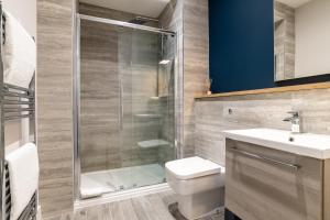a bathroom with a shower and a toilet and a sink at * Ground Floor * The Grove * in Aberdeen +3 photos