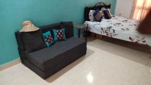 a living room with a couch and a bed at Palms Cosy affordable homely flat in Arpora +2 photos