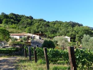 ein Bauernhaus auf einem Hügel hinter einem Zaun in der Unterkunft Agriturismo Fontenuova in Saturnia