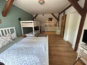 a bedroom with a bed and a bunk bed at Ferienzimmer Teiselsmühle Gehren Heideblick in Heideblick