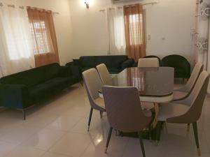 a living room with a couch and a table and chairs at VILLA ONu in Ouagadougou