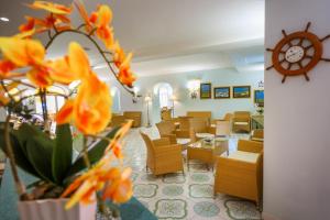 a waiting room with orange flowers and chairs at Hotel Rivamare in Ischia