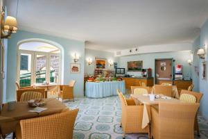 a restaurant with tables and chairs and a kitchen at Hotel Rivamare in Ischia