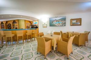a restaurant with tables and chairs and a bar at Hotel Rivamare in Ischia
