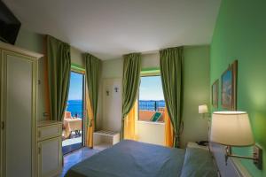 a bedroom with a bed with a view of the ocean at Hotel Rivamare in Ischia