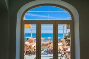 an arched window looking out at the ocean from a patio at Hotel Rivamare in Ischia