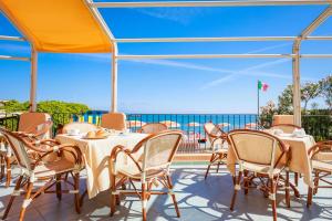 a patio with tables and chairs on a roof at Hotel Rivamare in Ischia