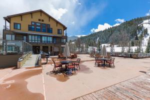 un patio con tavoli e sedie di fronte a un edificio di Slopeside #2775 by Summit County Mountain Retreats a Keystone