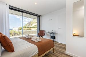 une chambre avec un lit et une grande fenêtre dans l'établissement Atlantic Gem by Homie, à Câmara de Lobos 30 autres photos