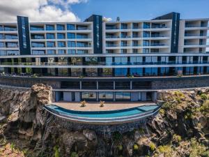 un immeuble de bureaux avec un bateau devant dans l'établissement Atlantic Gem by Homie, à Câmara de Lobos