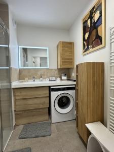 a bathroom with a washing machine and a sink at Valras-Loc Archipel Panarea Spa confort in Valras-Plage