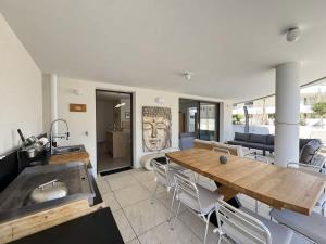 a kitchen and dining room with a wooden table at Valras-Loc Archipel Panarea Spa confort in Valras-Plage