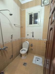 a bathroom with a toilet and a window and a shower at اجنحة الشام بلس in Al Madinah