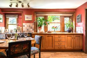 a kitchen with red walls and a table with chairs at Historic Hidden Gem-10mins walk to Holmfirth, Log Burner,Easy Parking in Holmfirth +19 photos