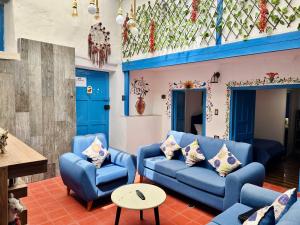 Una sala de estar con sofás azules y una mesa. en AITANA'S HOUSE - SAN BLAs, en Cusco