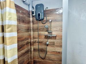 y baño con ducha y pared de madera. en AITANA'S HOUSE - SAN BLAs, en Cusco