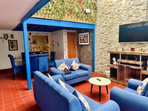 sala de estar con sofás azules y TV en AITANA'S HOUSE - SAN BLAs, en Cusco