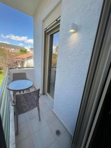 a balcony with a table and a chair and a window at Annabell Houses & Rooms Raches in Paralia Rachon