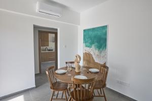 a dining room with a wooden table and chairs at Adamandri Lodge - Prime Location in Ayia Napa