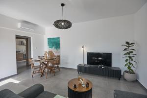 a living room with a couch and a table at Adamandri Lodge - Prime Location in Ayia Napa